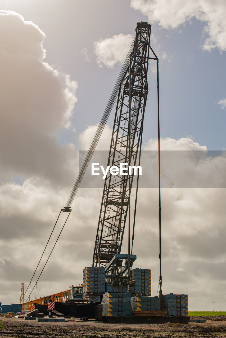 LOW ANGLE VIEW OF CRANE AGAINST SKY AT CONSTRUCTION SITE