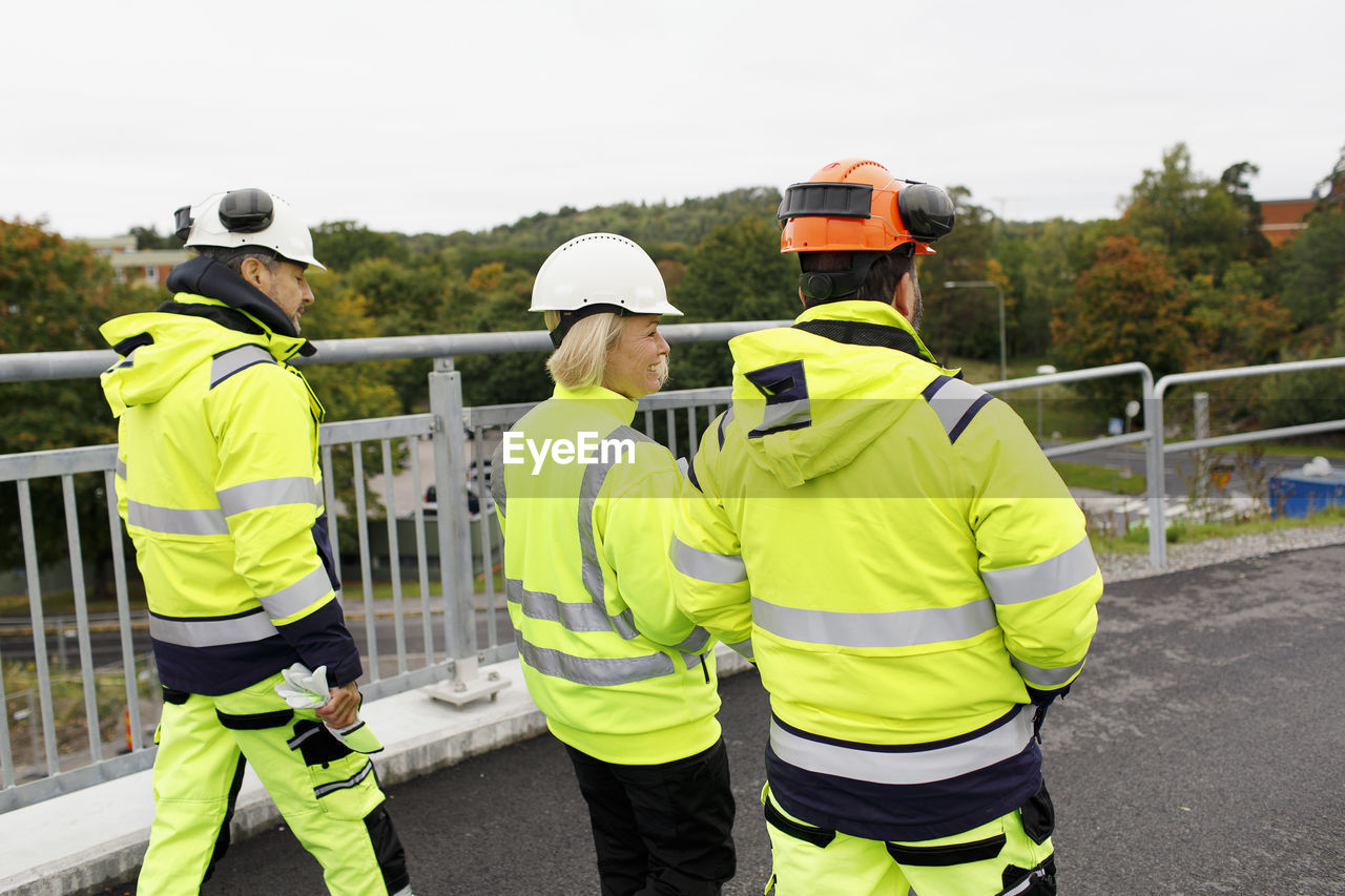 Engineers in reflective clothing walking on bridge
