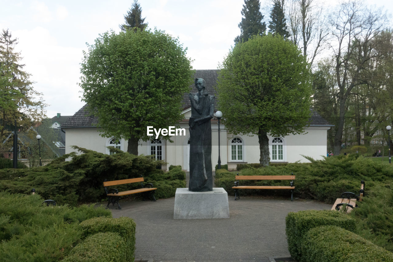 STATUE AGAINST TREES AND SKY