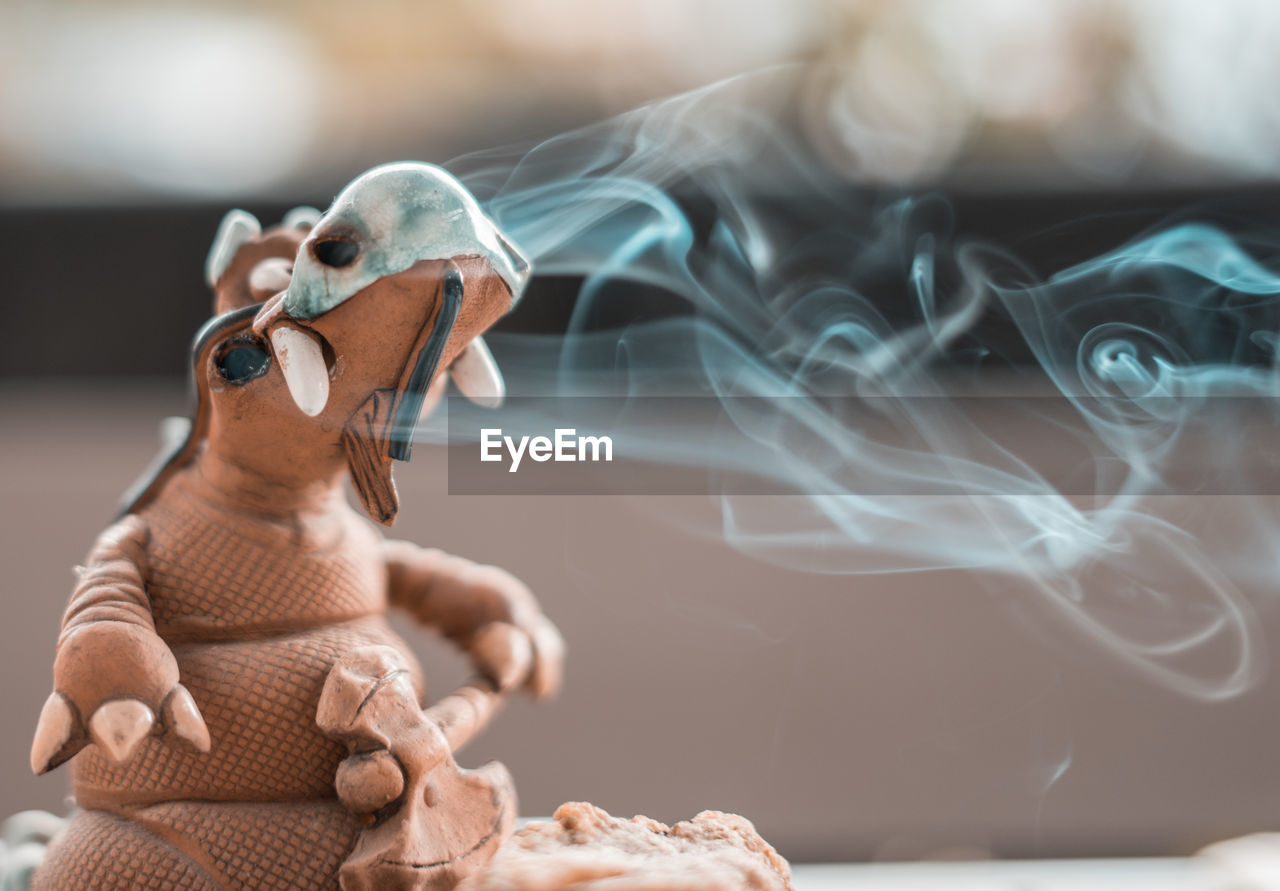 Close-up of smoke emitting from dragon figurine