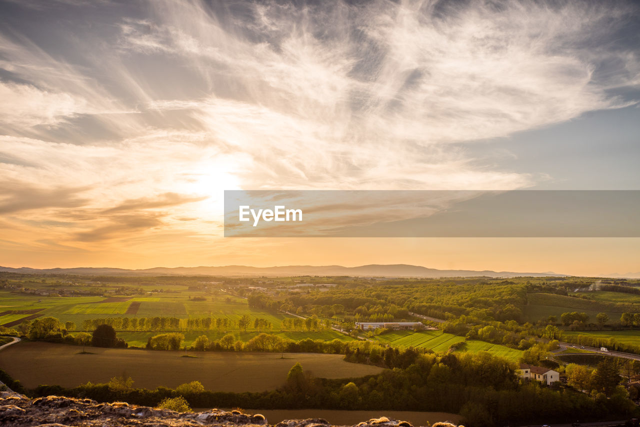 SCENIC VIEW OF AGRICULTURAL FIELD AGAINST SKY AT SUNSET