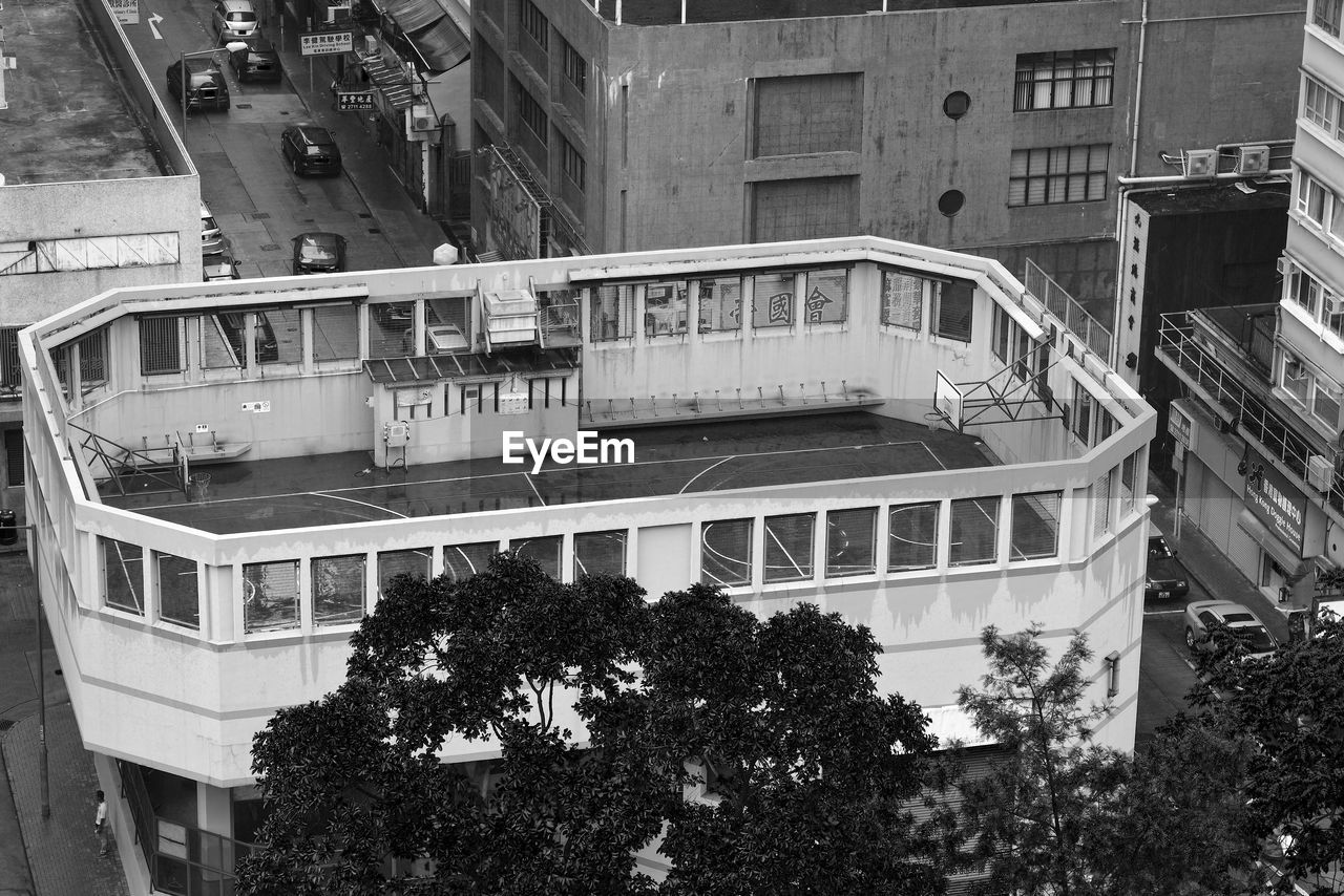 HIGH ANGLE VIEW OF BUILDINGS BY TREES