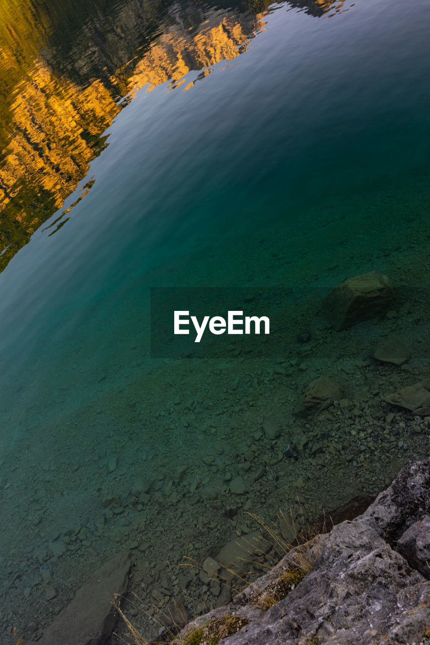 HIGH ANGLE VIEW OF ROCKS ON SEA