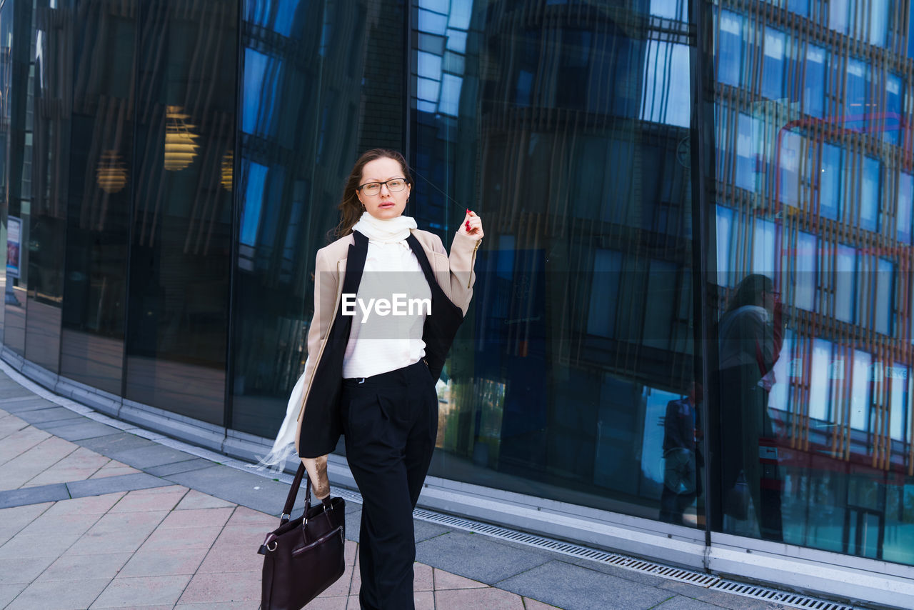 Successful happy business woman with bag over office building background person