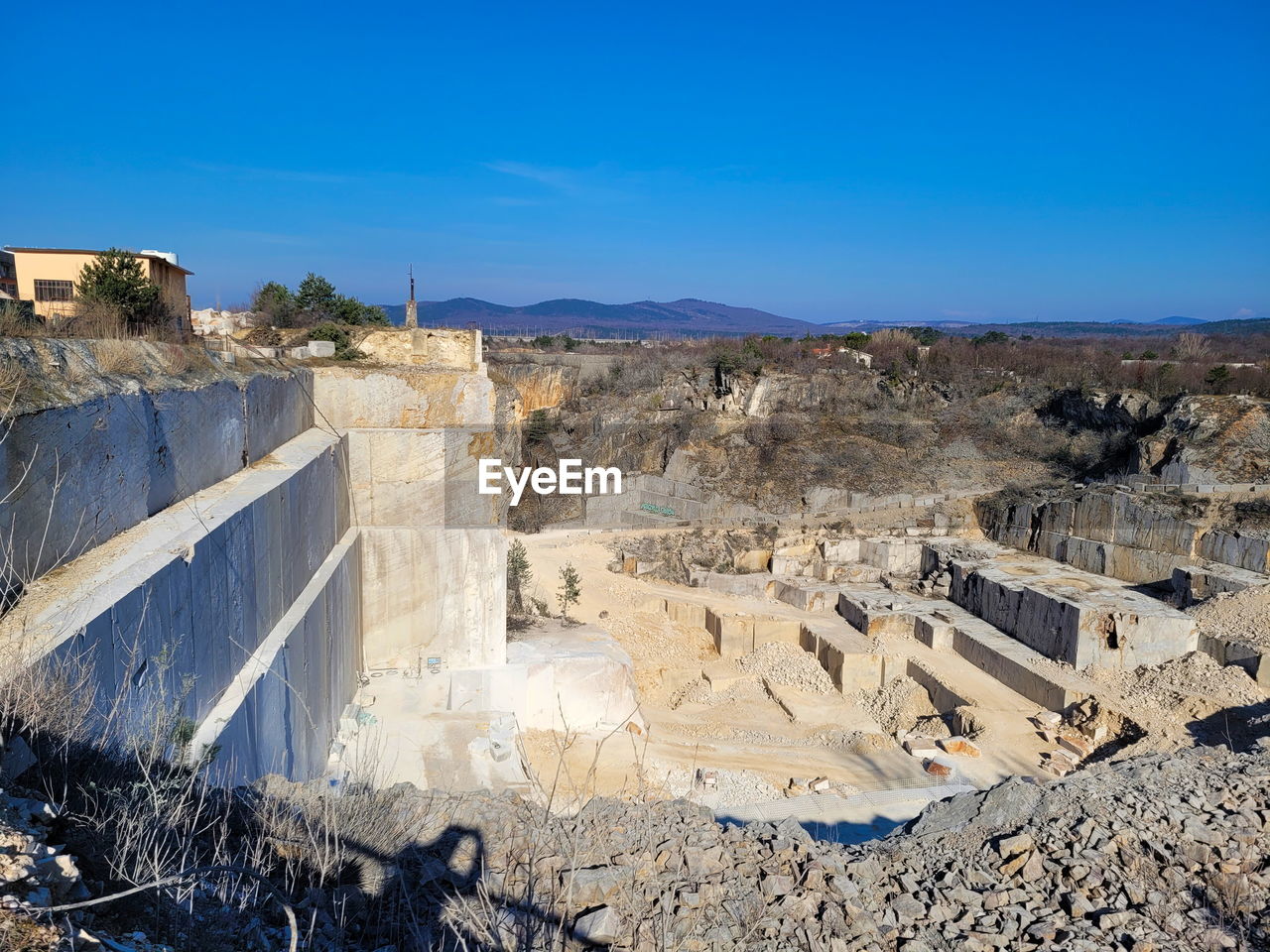 nature, architecture, sky, environment, quarry, ancient history, ruins, blue, built structure, no people, industry, clear sky, terrain, land, geology, mining, landscape, travel destinations, wall, rock, travel, day, outdoors, power generation, history, sunny, scenics - nature, sunlight, cliff