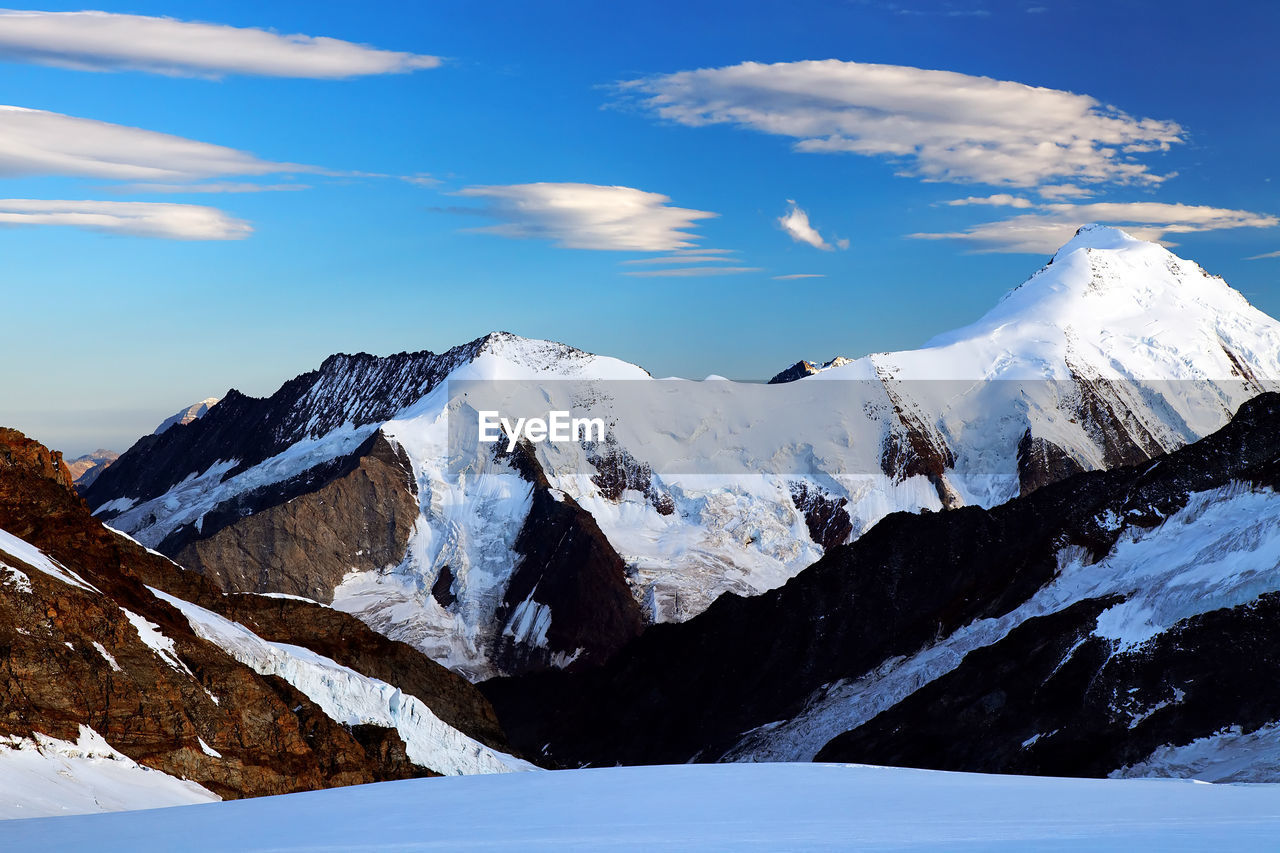 Scenic view of snow covered mountain against blue sky at swiss alps