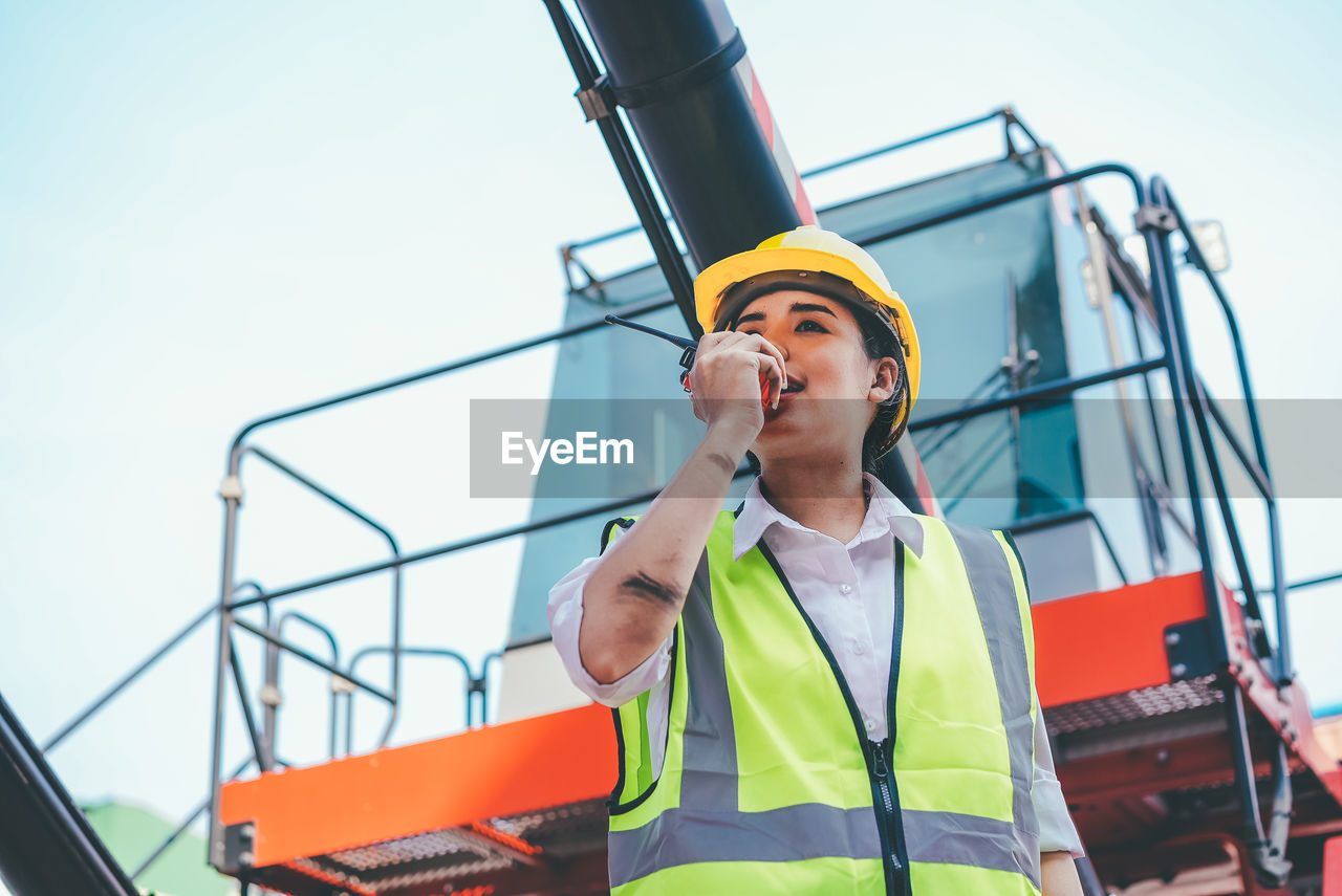 LOW ANGLE VIEW OF SENIOR MAN WORKING AT CONSTRUCTION SITE