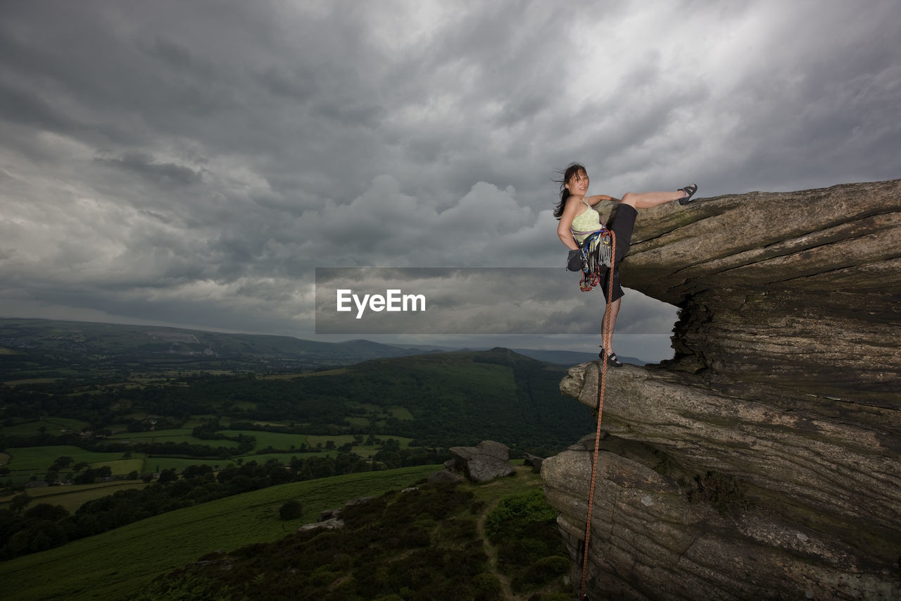 Female rock climber on cliff at the peak district in england