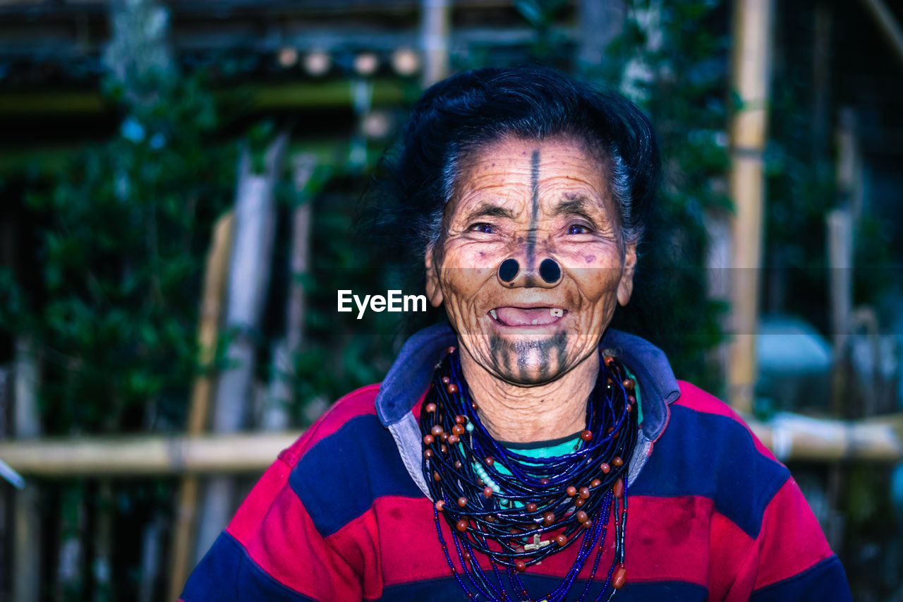 Apatani tribal women facial expression with her traditional nose lobes and blurred background