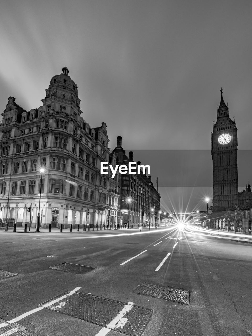 Light trails on street against big ben at night