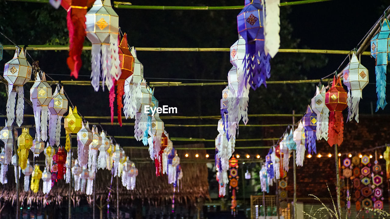 LOW ANGLE VIEW OF LANTERNS HANGING IN ROW