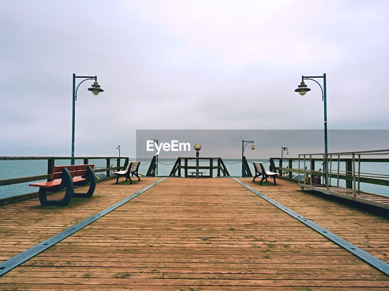 Abandoned seaside telescope . autumn misty morning on wooden pier above sea. dark atmosphere.