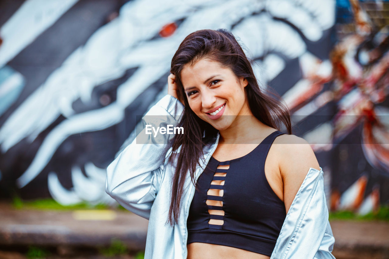 PORTRAIT OF SMILING YOUNG WOMAN