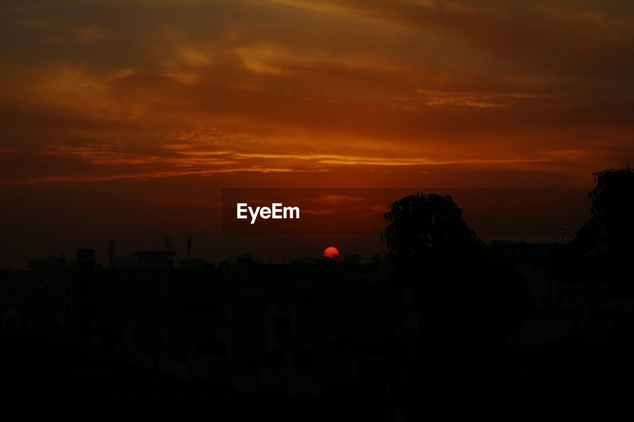 Silhouette buildings against sky during sunset