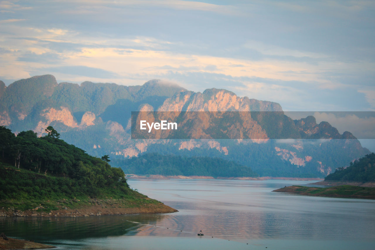 Scenic view of sea and mountains against sky