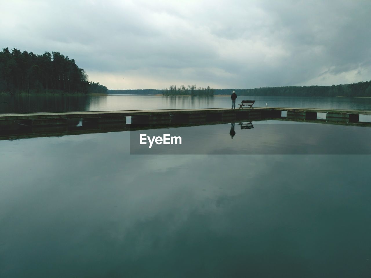 Scenic view of calm lake against cloudy sky