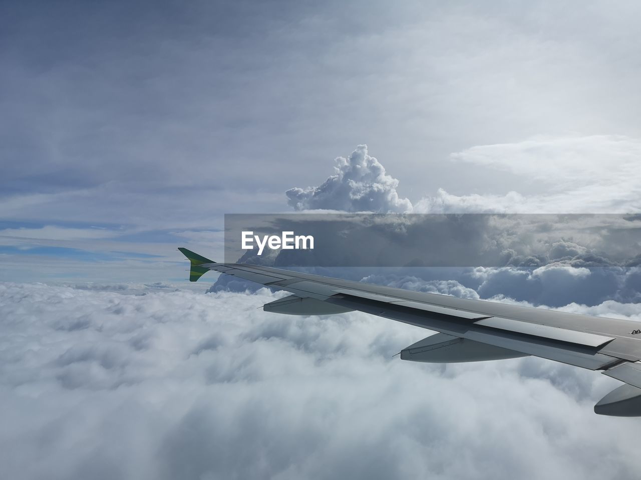 Airplane flying over clouds against sky