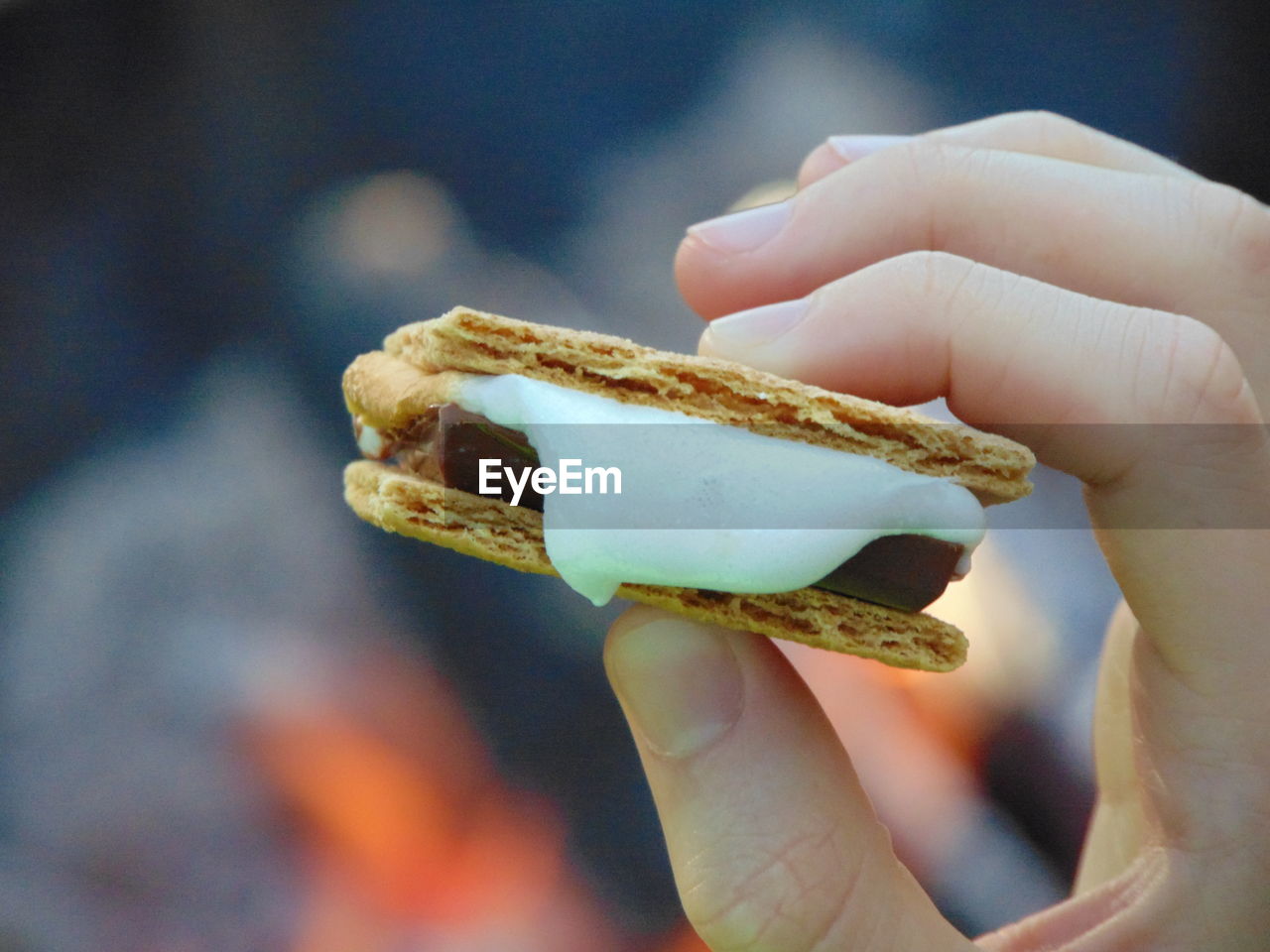 Close-up of human hand holding smore