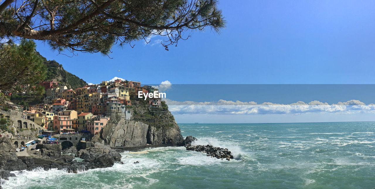 Scenic view of sea by cliff against sky