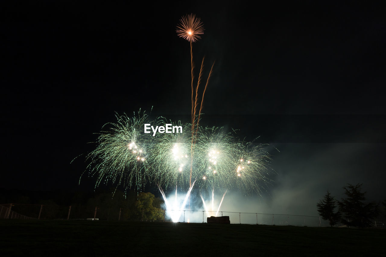 Low angle view of firework display at night