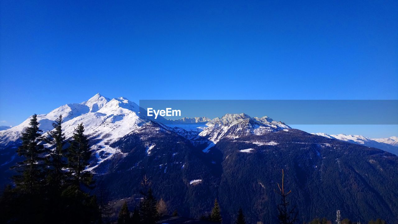 SNOWCAPPED MOUNTAINS AGAINST CLEAR BLUE SKY