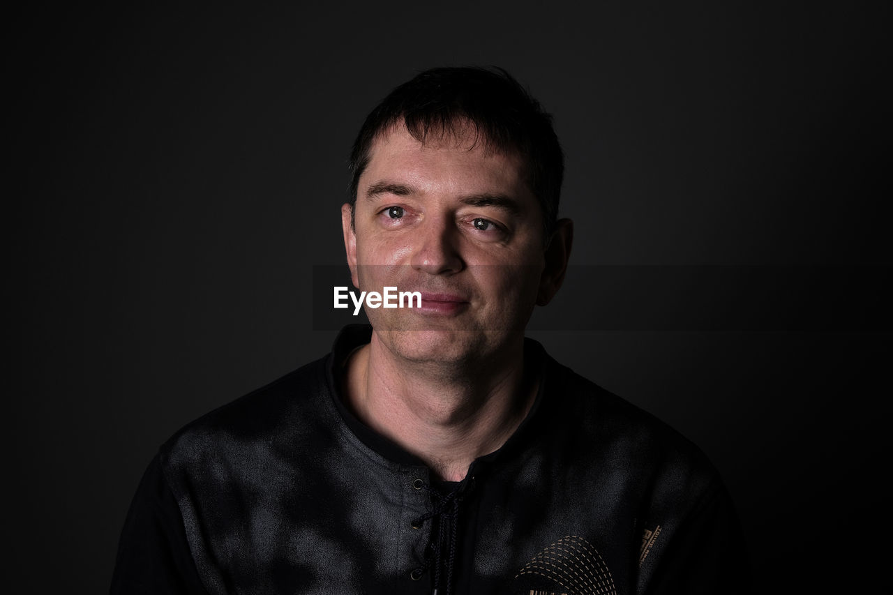 Smiling man against black background