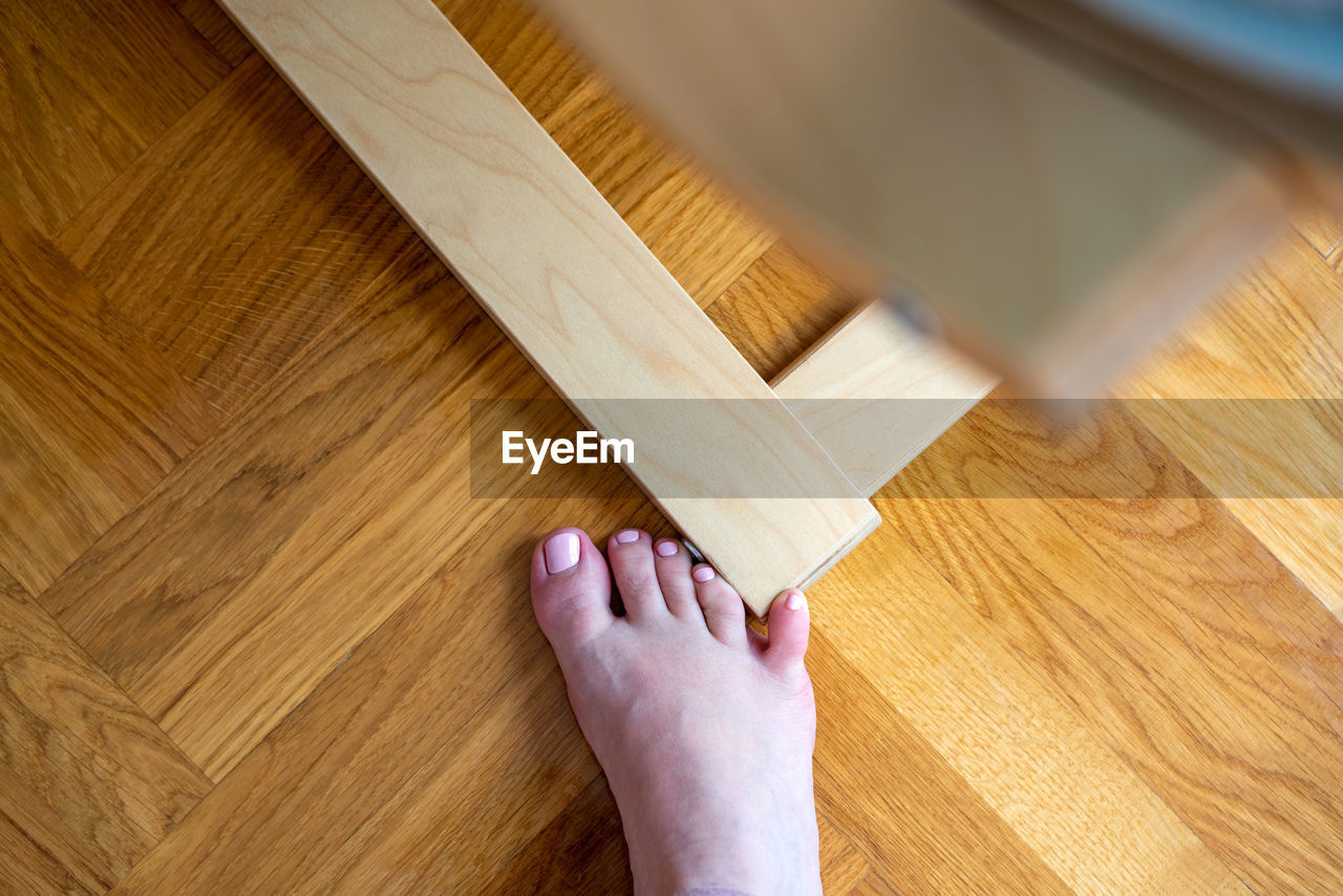 hardwood floor, wood, one person, flooring, floor, indoors, home interior, adult, hand, lifestyles, hardwood, high angle view, domestic life, personal perspective, close-up, home improvement, wood stain, parquet floor, diy, cleaning, wood flooring