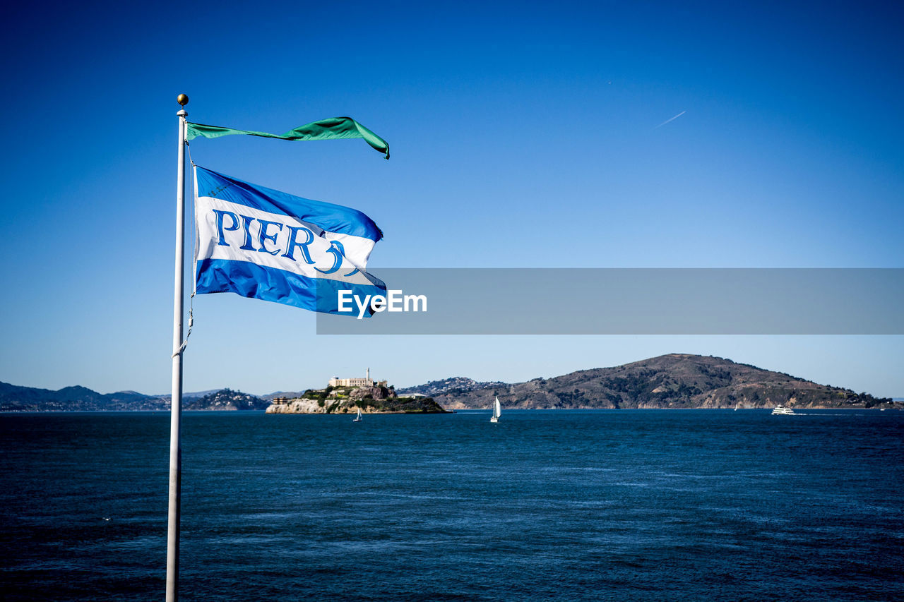 INFORMATION SIGN BY SEA AGAINST CLEAR SKY