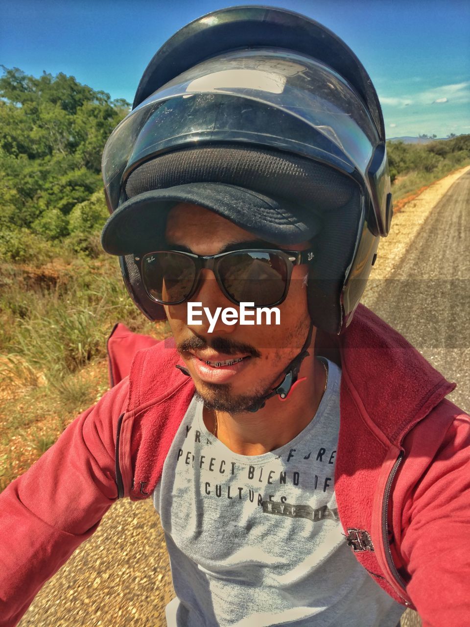 PORTRAIT OF YOUNG MAN WEARING SUNGLASSES AGAINST SKY