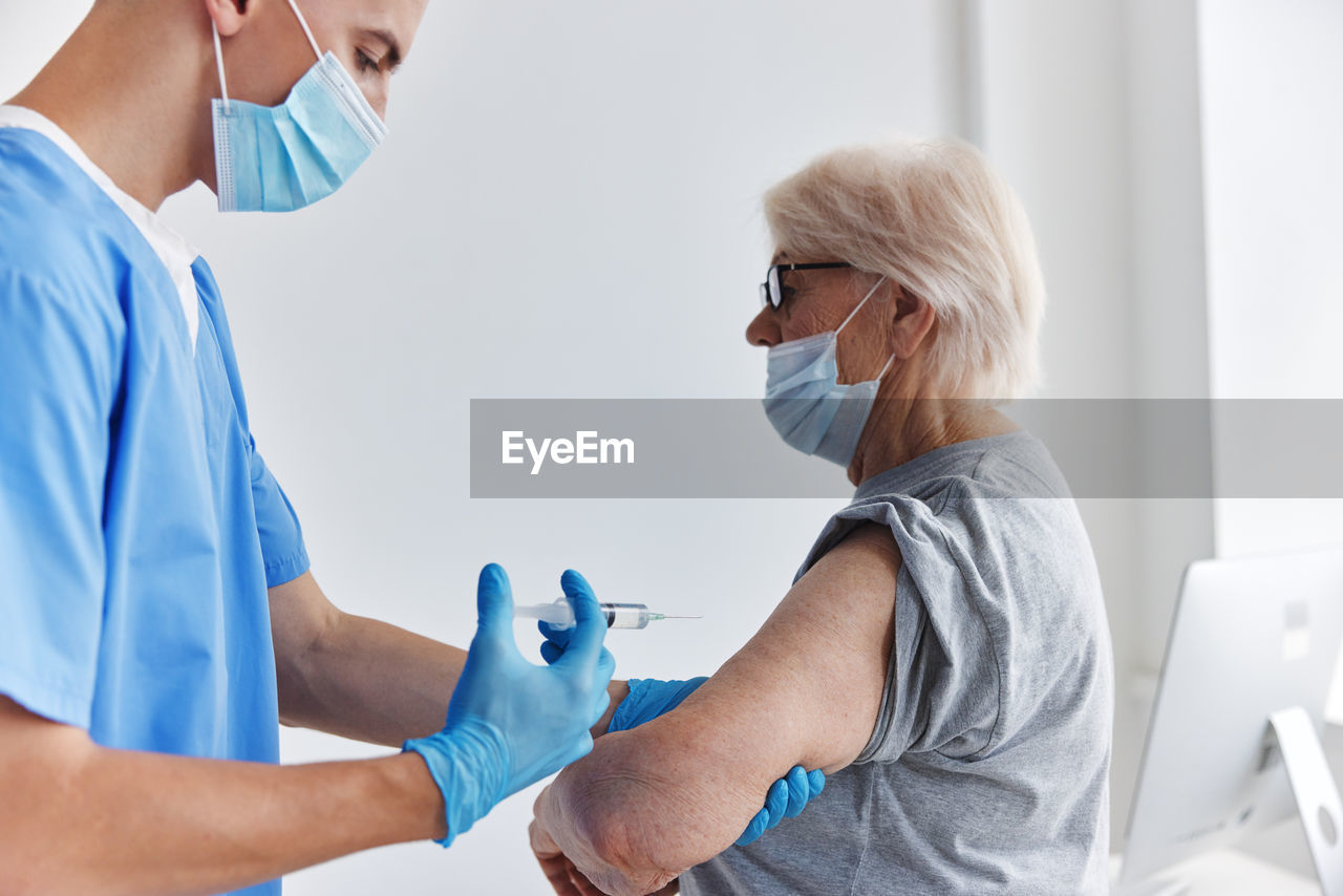 Side view of doctor examining patient at clinic