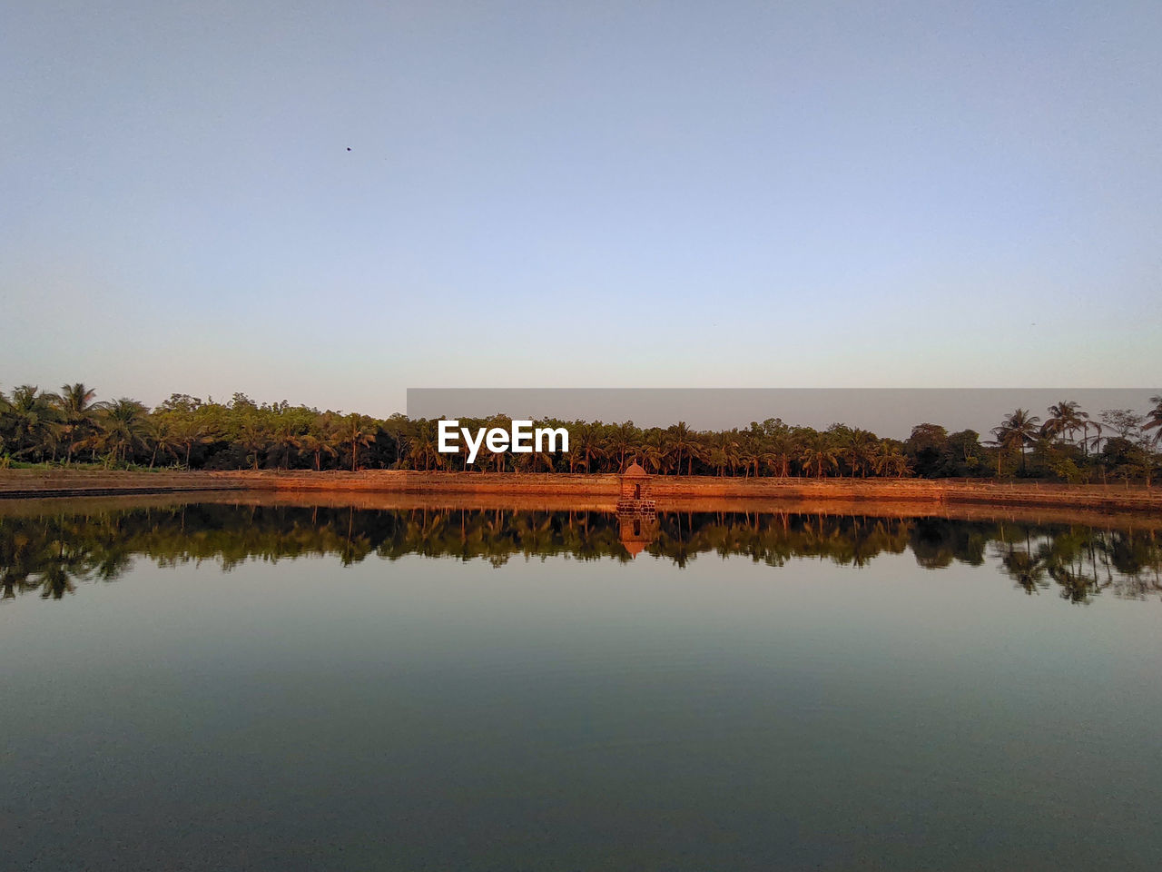 SCENIC VIEW OF LAKE AGAINST CLEAR SKY DURING SUNSET