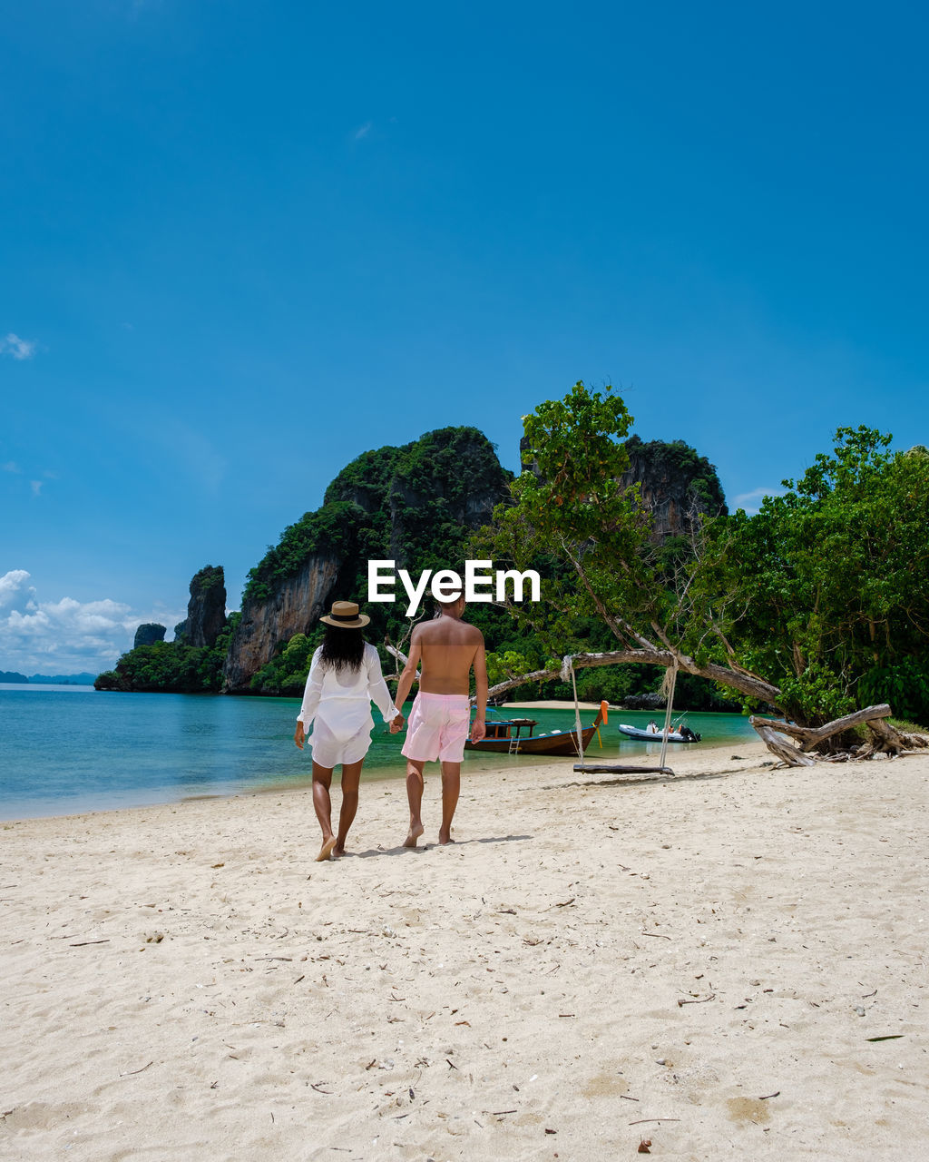 rear view of people at beach against sky