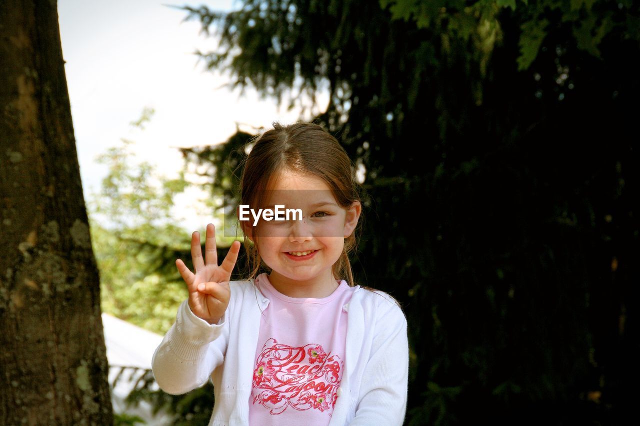 Portrait of happy girl showing fingers