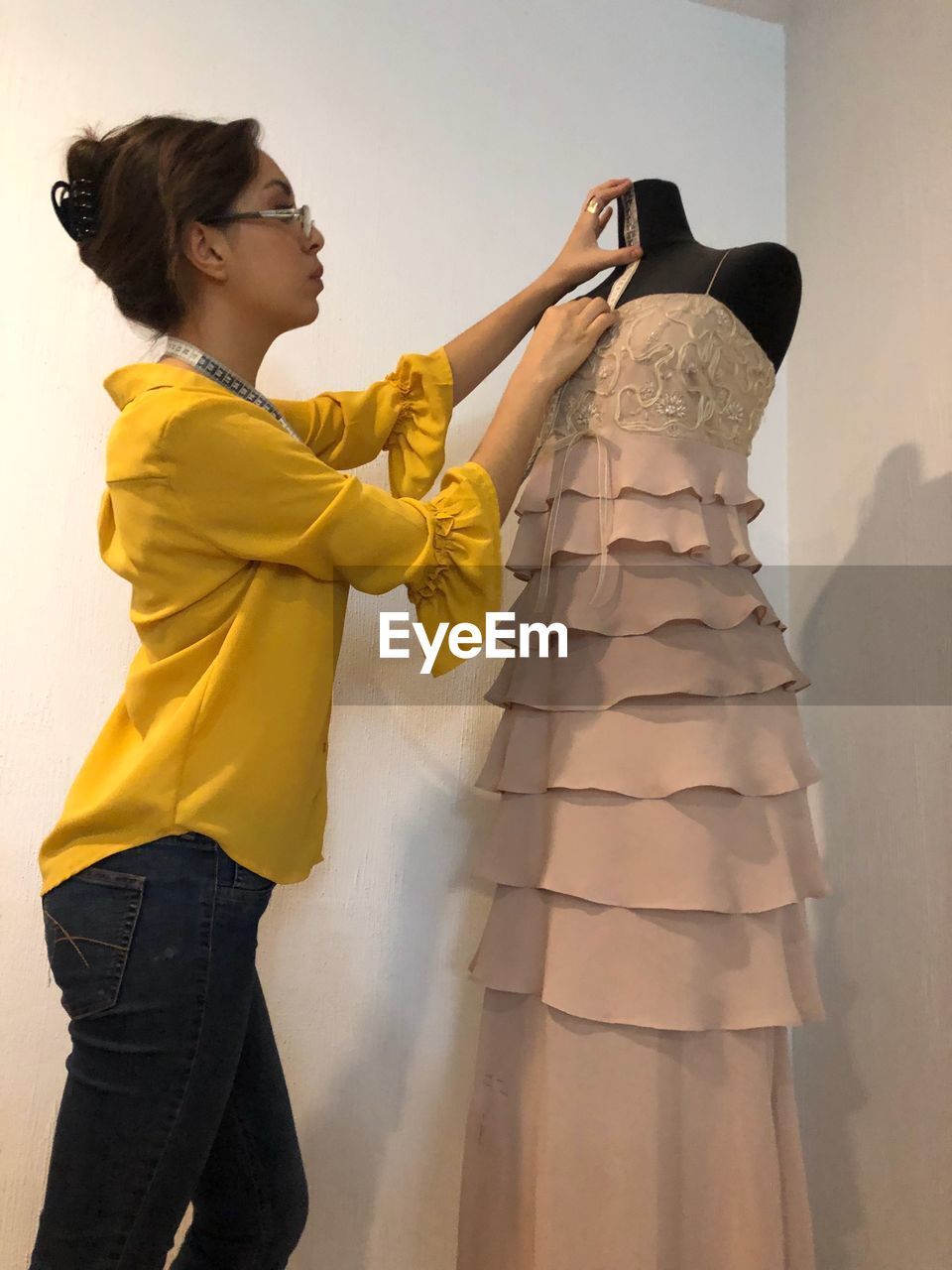 Fashion designer measuring mannequin neck in store