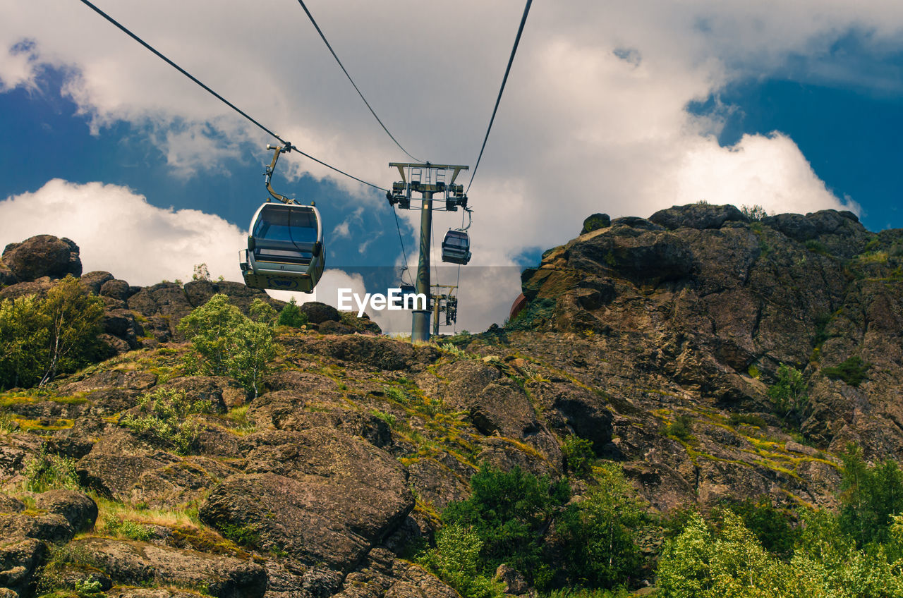 Low angle view of overhead cable car against mountain