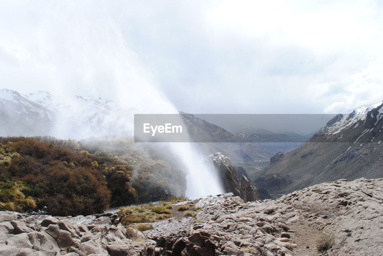 Scenic view of waterfall against sky