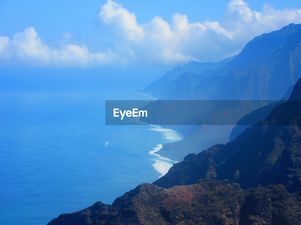 Scenic view of mountains against blue sky