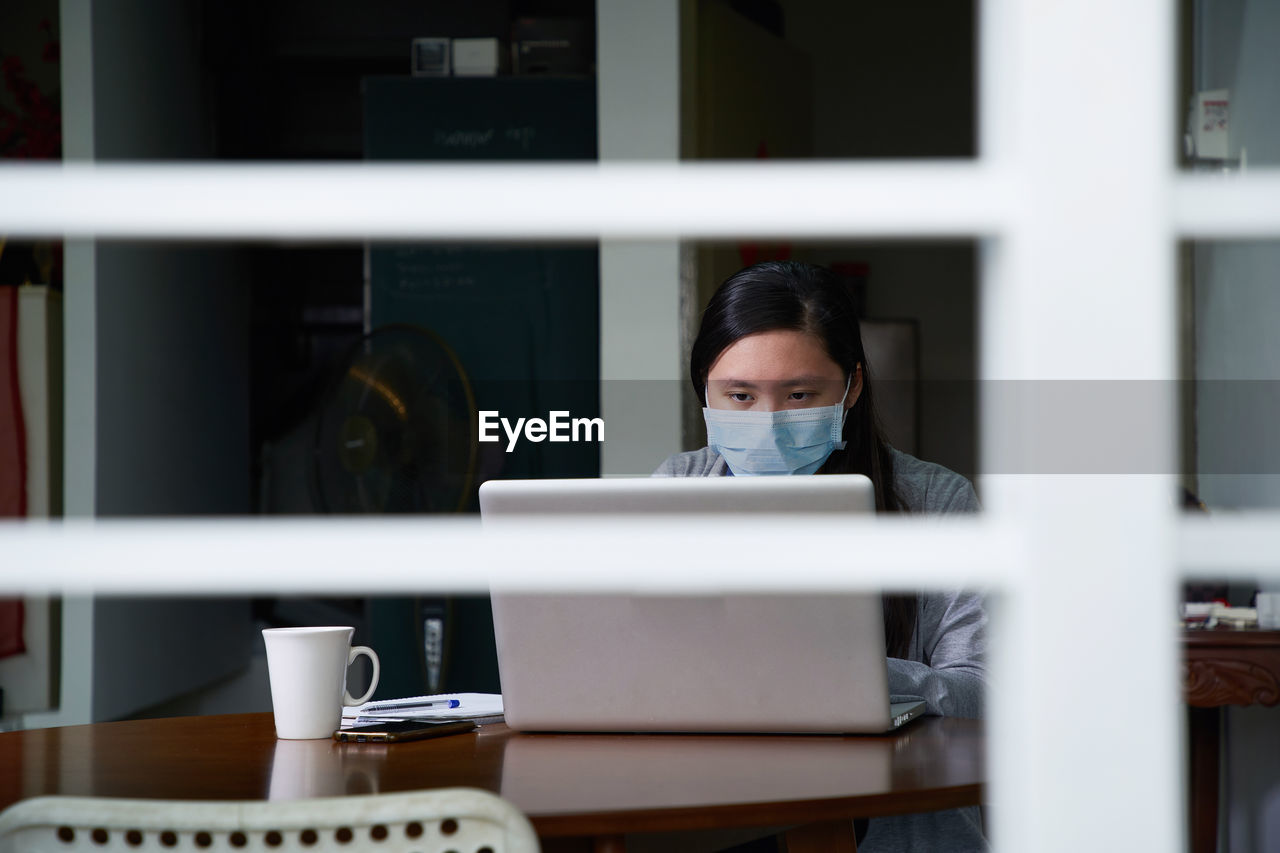  portrait of young woman wearing face mask have online class   