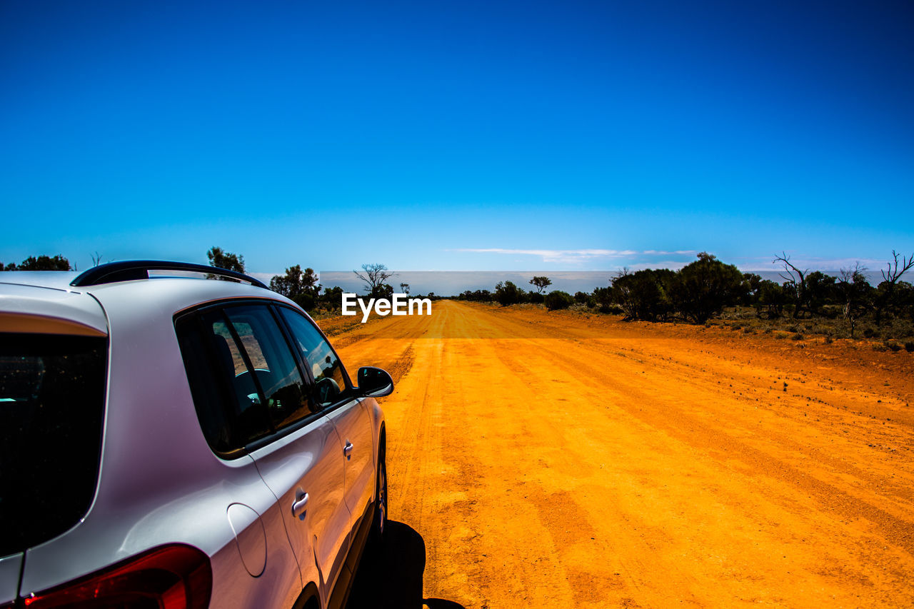 View of car on road against clear blue sky