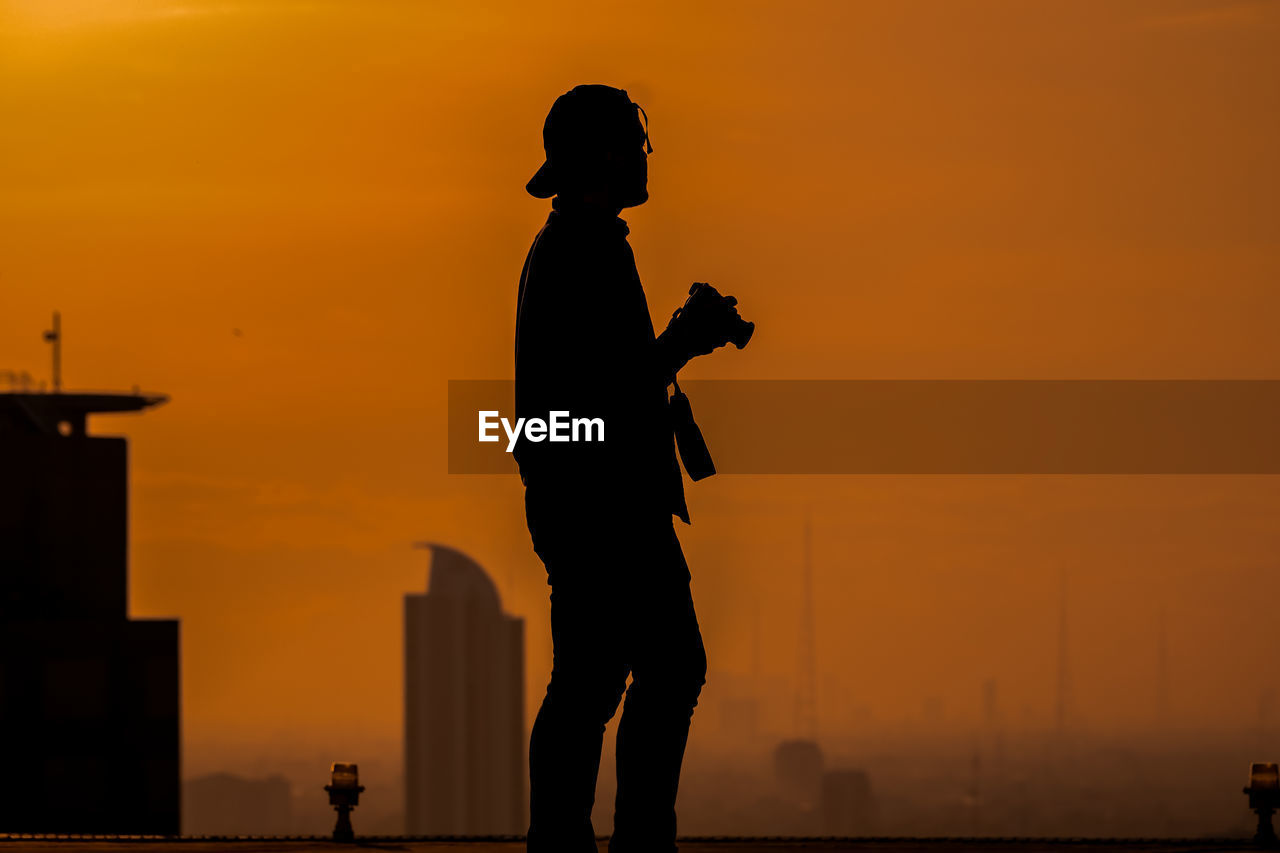 Silhouette man standing against sky during sunset 