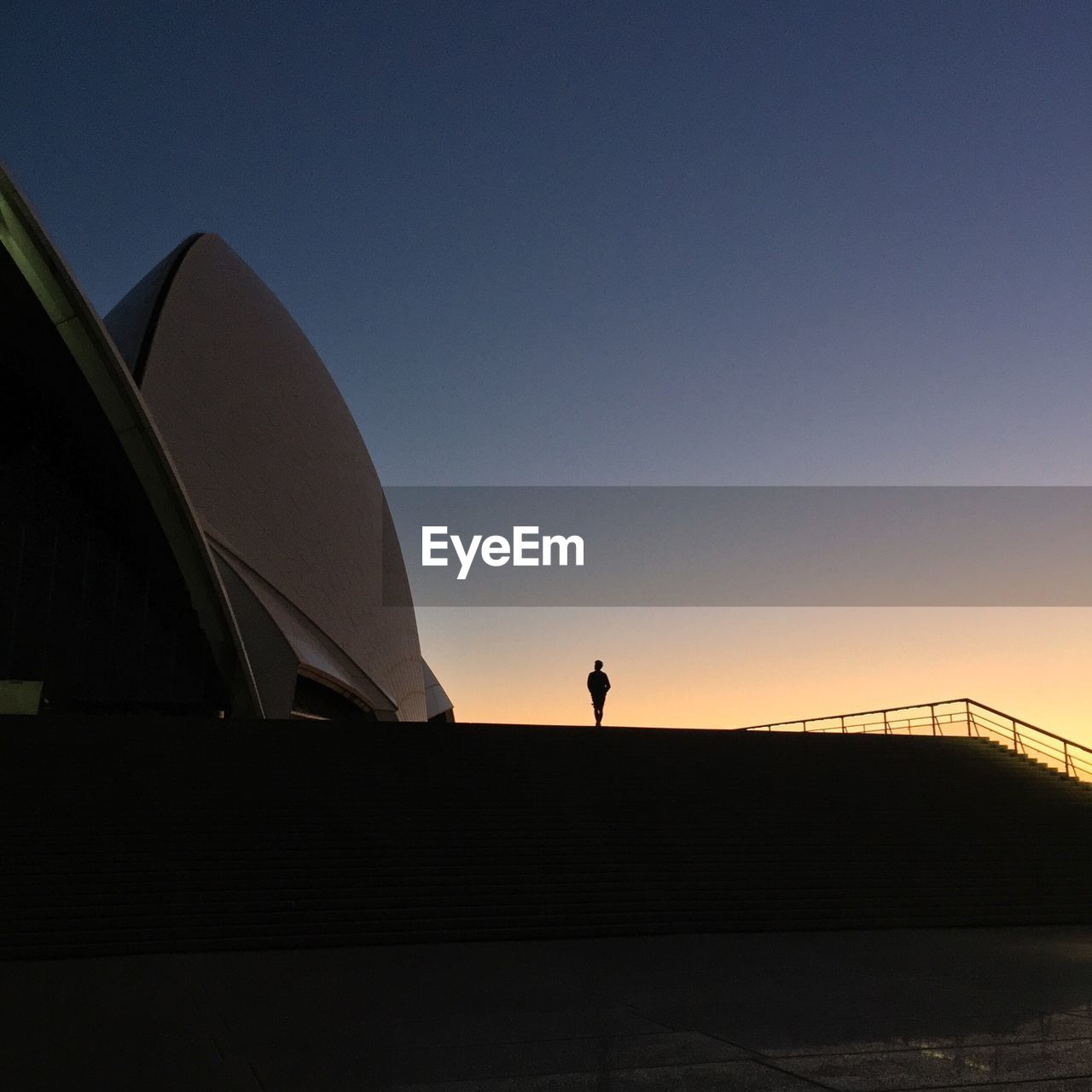 LOW ANGLE VIEW OF SILHOUETTE WOMAN STANDING AT DUSK