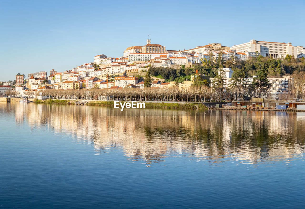 SCENIC VIEW OF LAKE BY BUILDINGS AGAINST CLEAR SKY