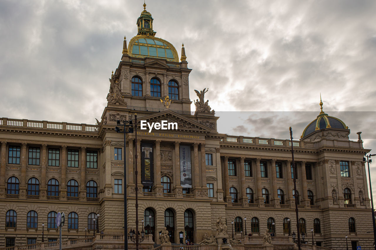 Low angle view of building against cloudy sky in prague 