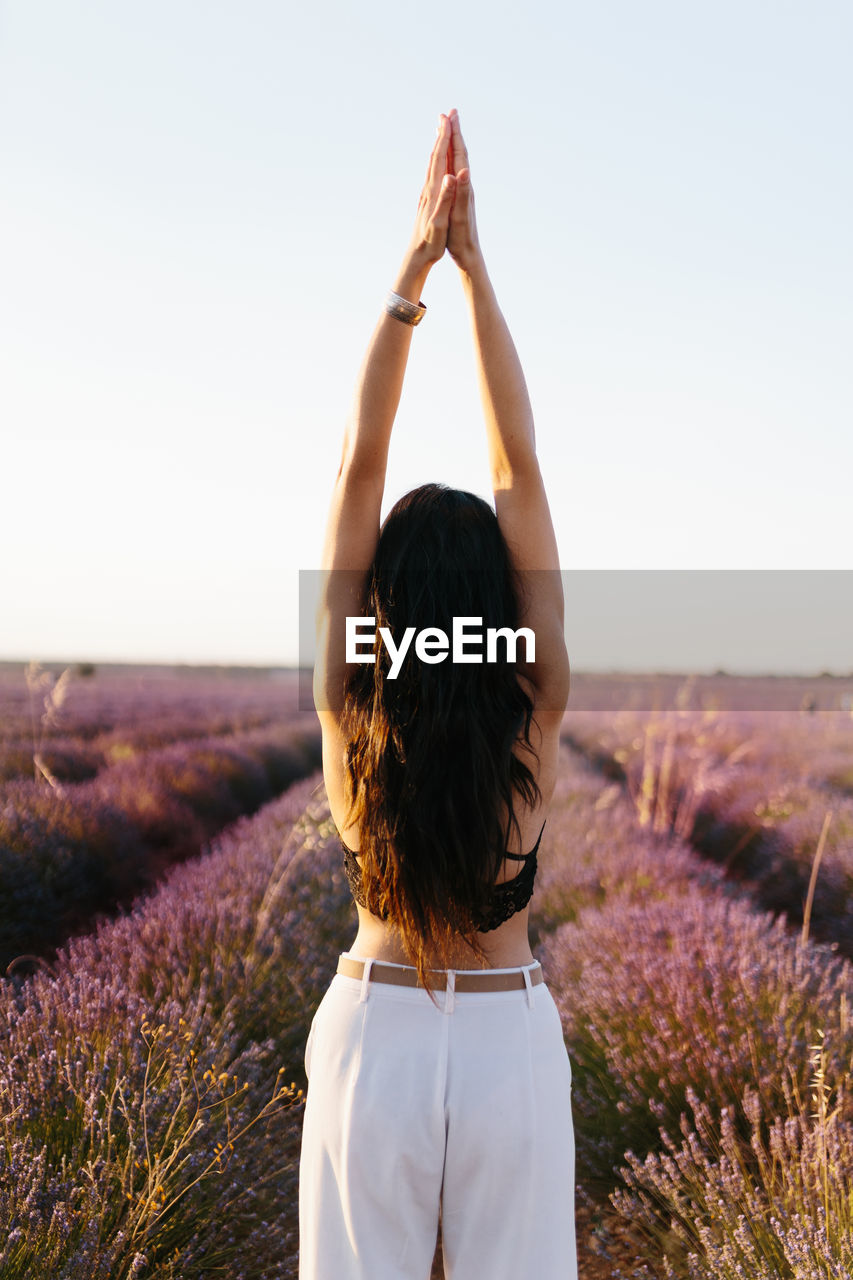 Brunette woman on her back stretching her in lavender field