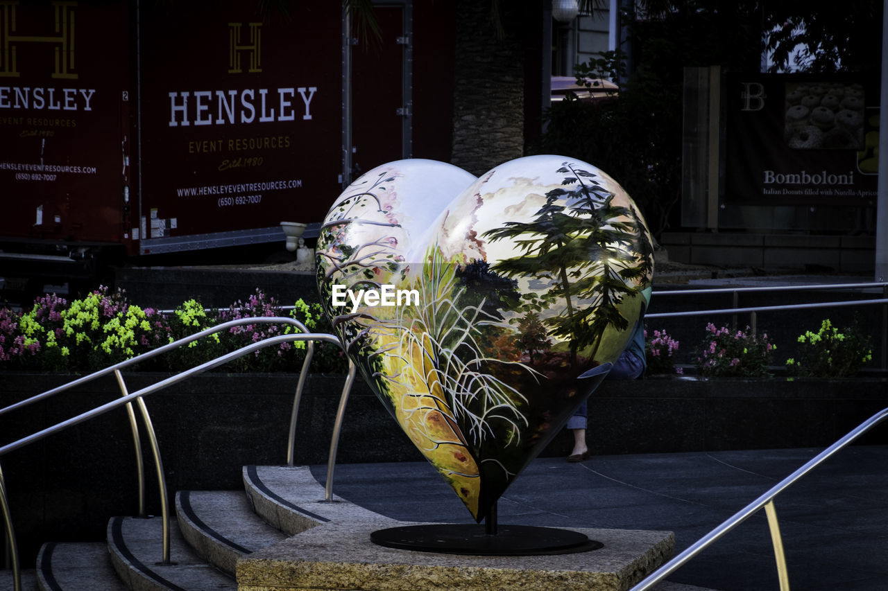 CLOSE-UP OF SCULPTURE BY FLOWER POTS