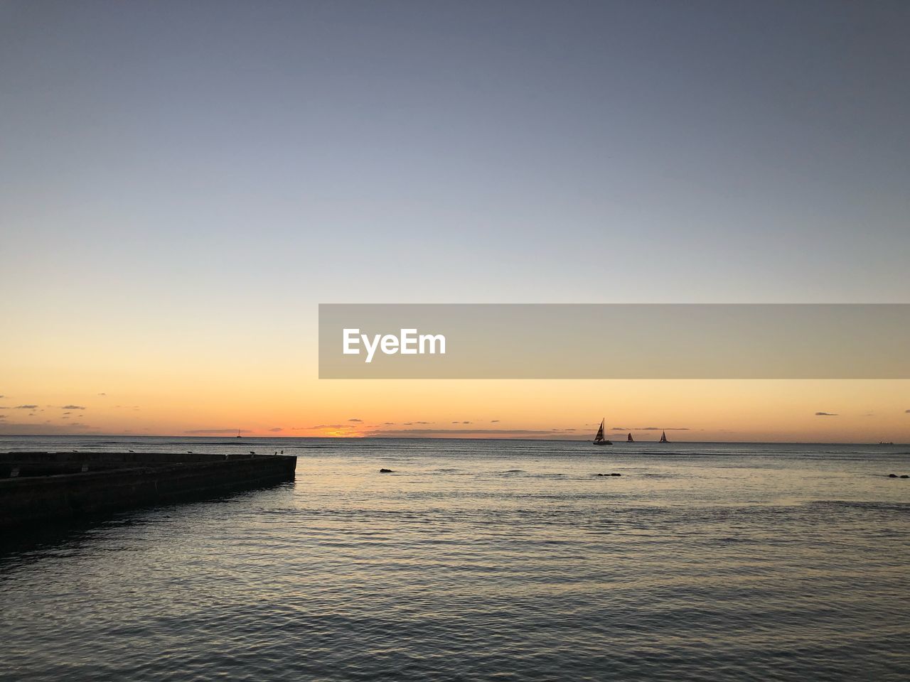 Scenic view of sea against clear sky during sunset