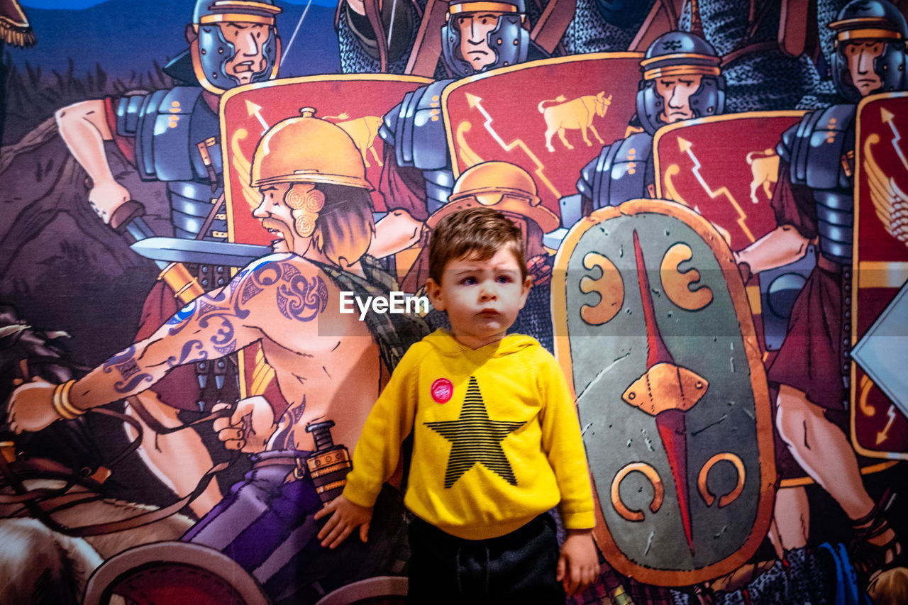 PORTRAIT OF BOY STANDING IN CAROUSEL