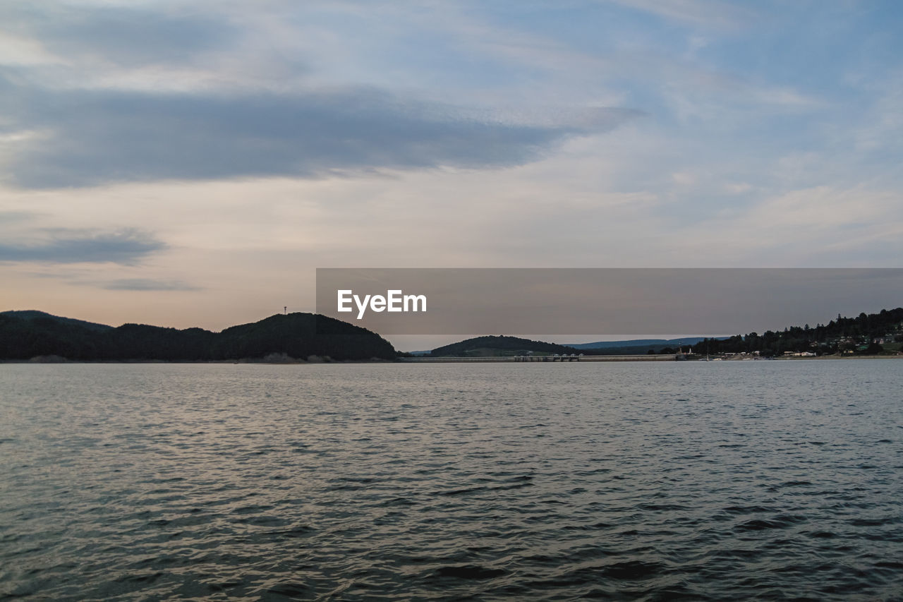 SCENIC VIEW OF SEA BY MOUNTAIN AGAINST SKY