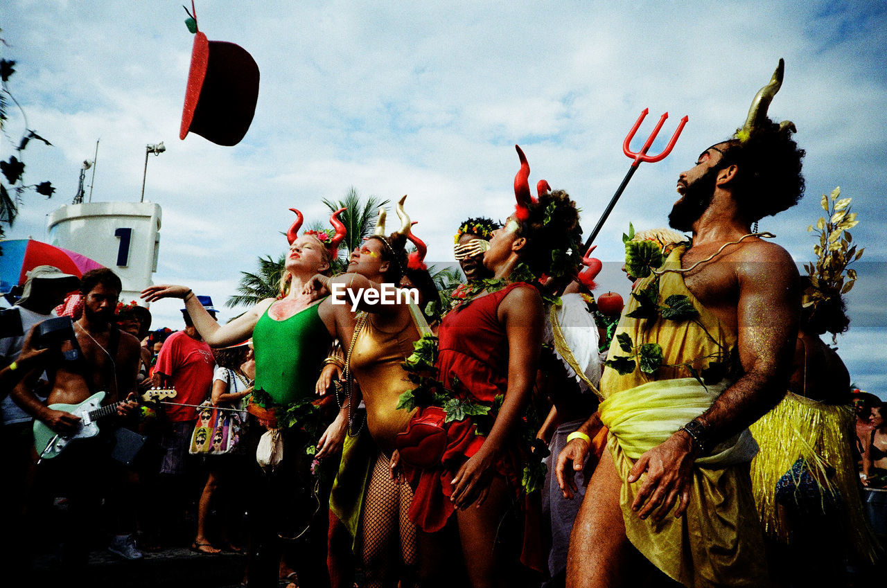 GROUP OF PEOPLE IN TRADITIONAL CLOTHING AGAINST SKY