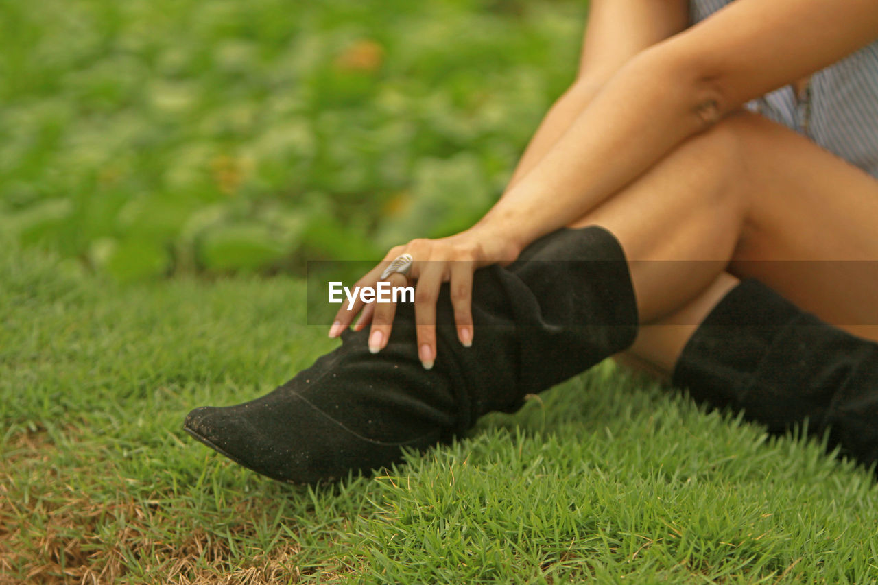 Low section of woman sitting on grass